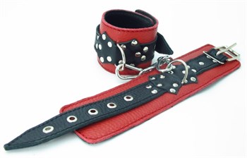 Красные наручники с чёрными проклёпанными ремешками с пряжкой 