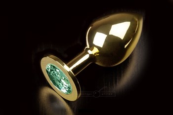 Большая золотая анальная пробка с закругленным кончиком и изумрудным кристаллом - 9 см.